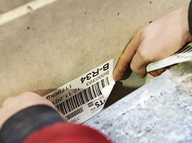 Arbeiter klebt ein Etikett auf eine Box