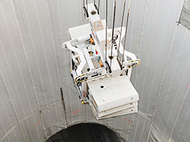 Crane letting down conrete elements into a hole