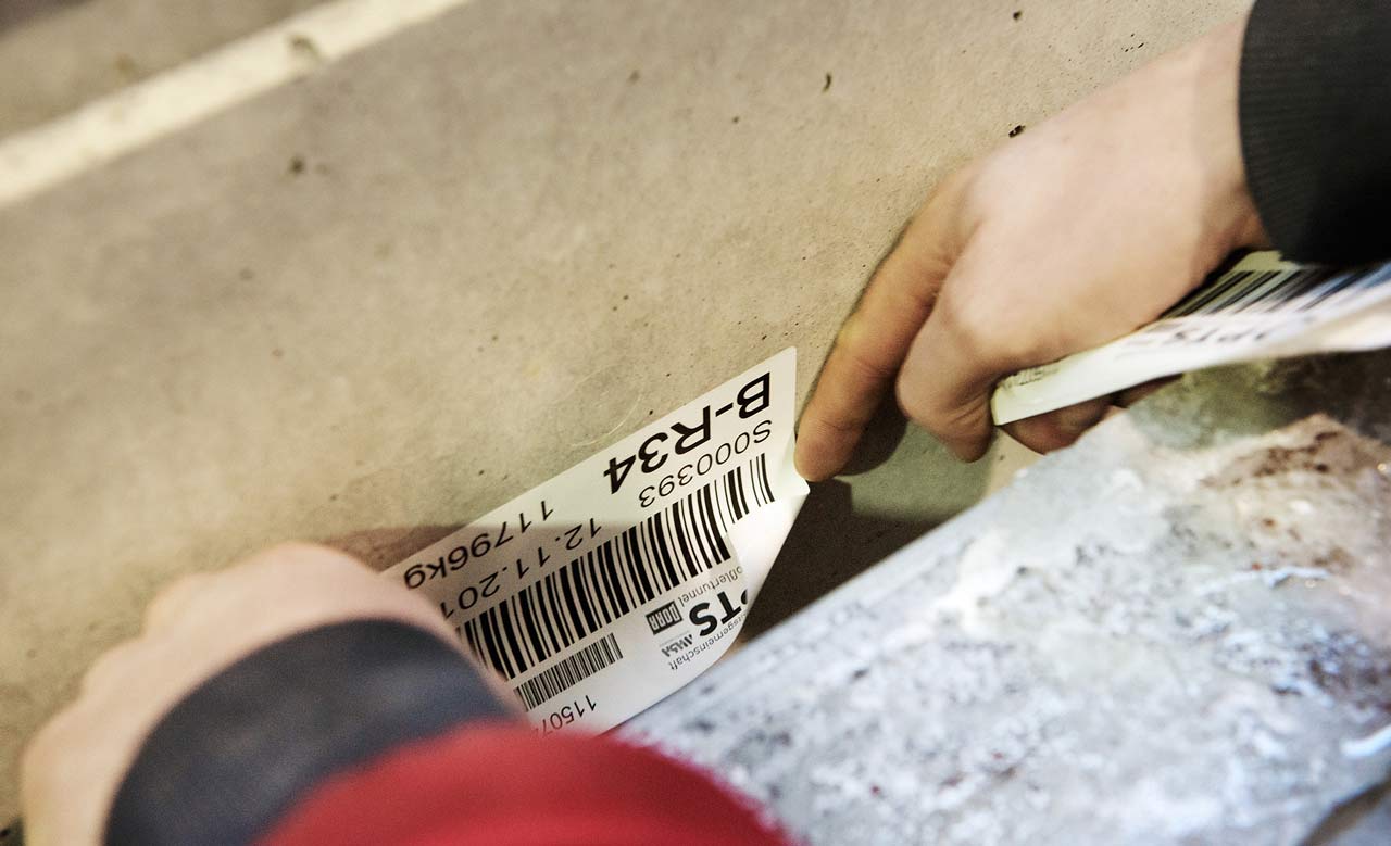 Arbeiter klebt ein Etikett auf eine Box